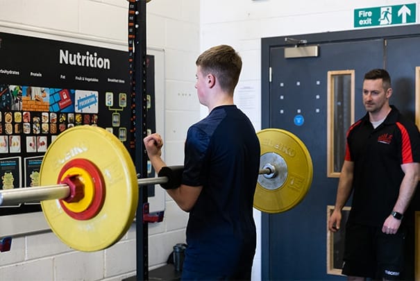 teen lifting weights at The Athlete Academy