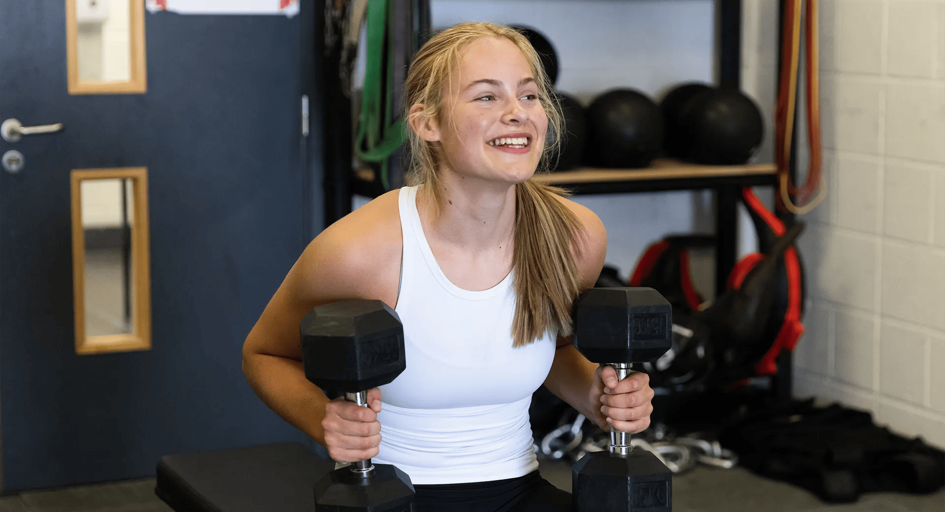 kid training with dumbbells